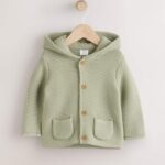 A cozy and cute organic cotton knitted cardigan with a hood and adorable 3D ears.