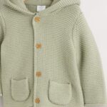 A cozy and cute organic cotton knitted cardigan with a hood and adorable 3D ears.